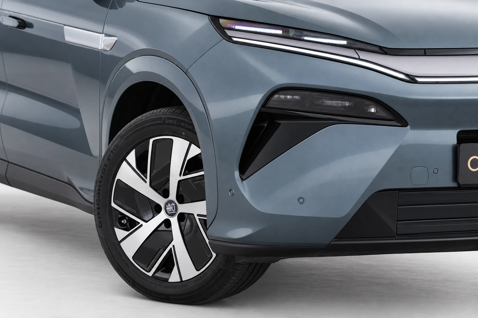 BYD Tang L, zbliżenie na przednią lampę, narożnik zderzaka i fragment koła.