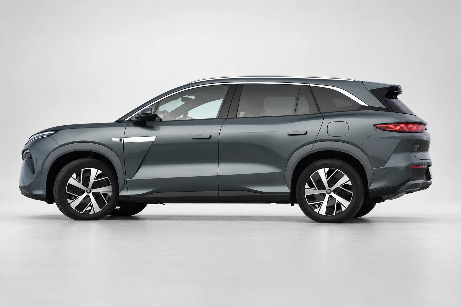 BYD Tang L z boku w szerszym kadrze, z wyraźną linią dachu i tylnym spojlerem.