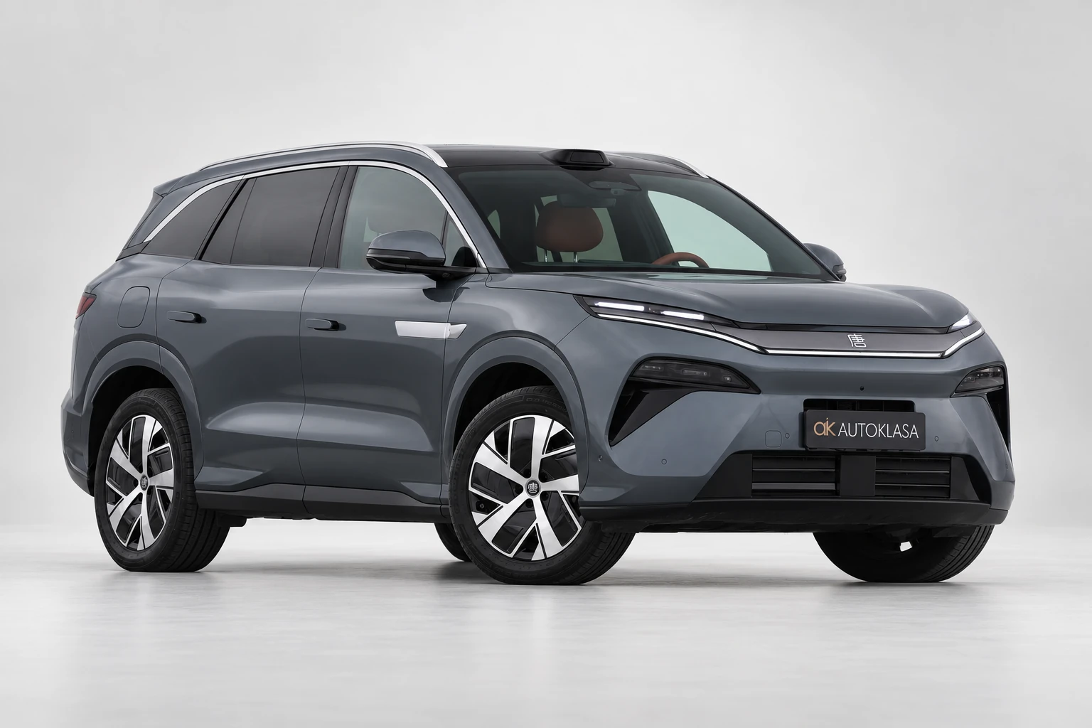 BYD Tang L w ciemnoszarym lakierze, całe auto od przodu pod kątem w jasnym studiu.