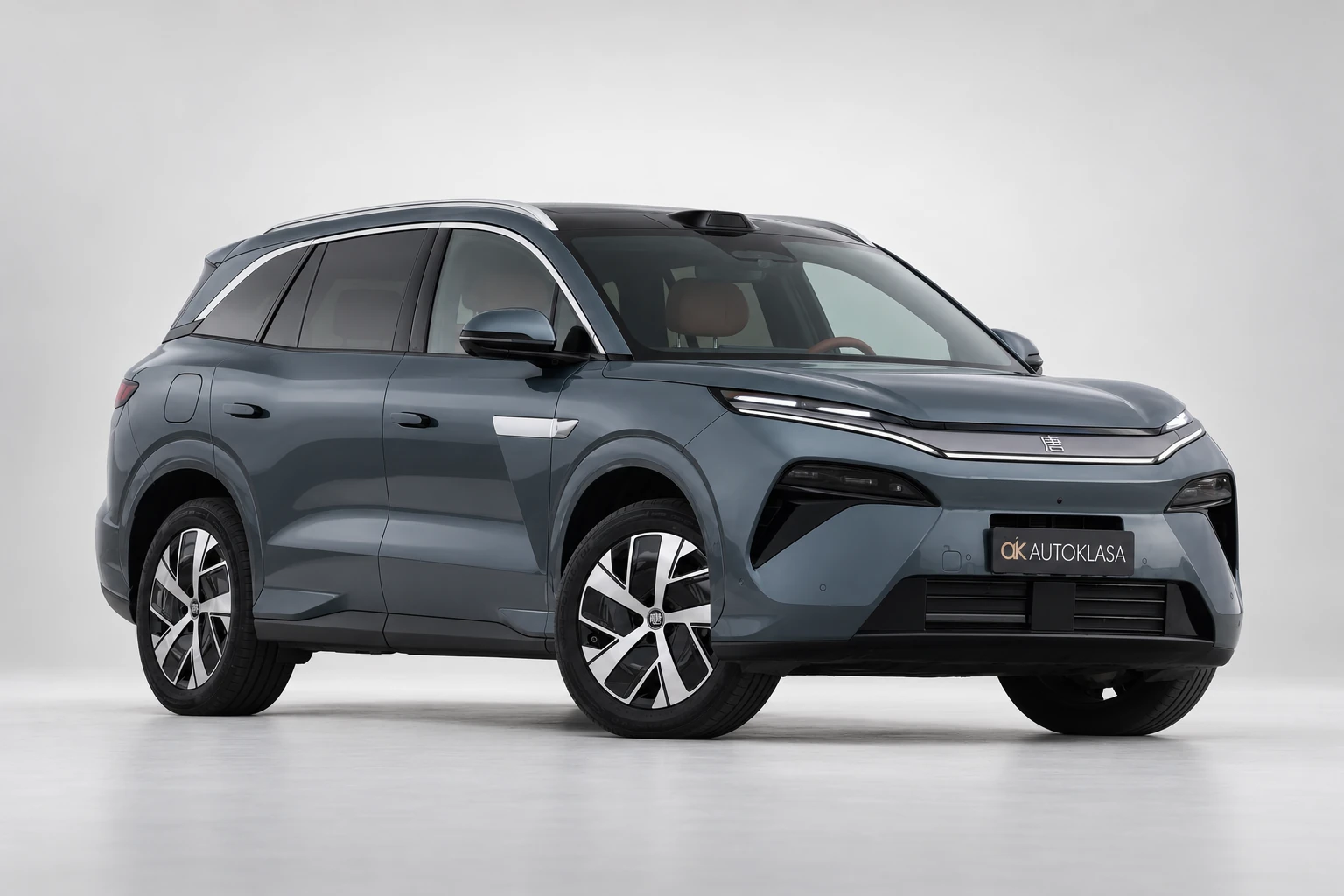 BYD Tang L od przodu i boku, z całą sylwetką oraz wolną przestrzenią wokół samochodu.