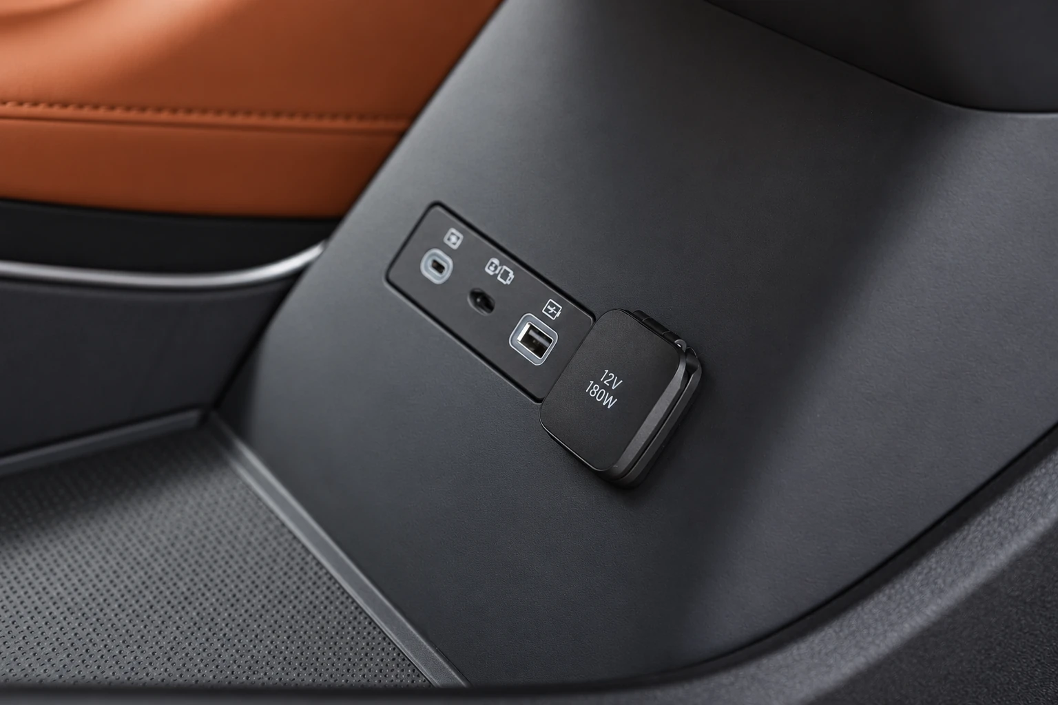 BYD Tang L, porty USB i zakryte gniazdo zasilania w dolnej części kabiny.