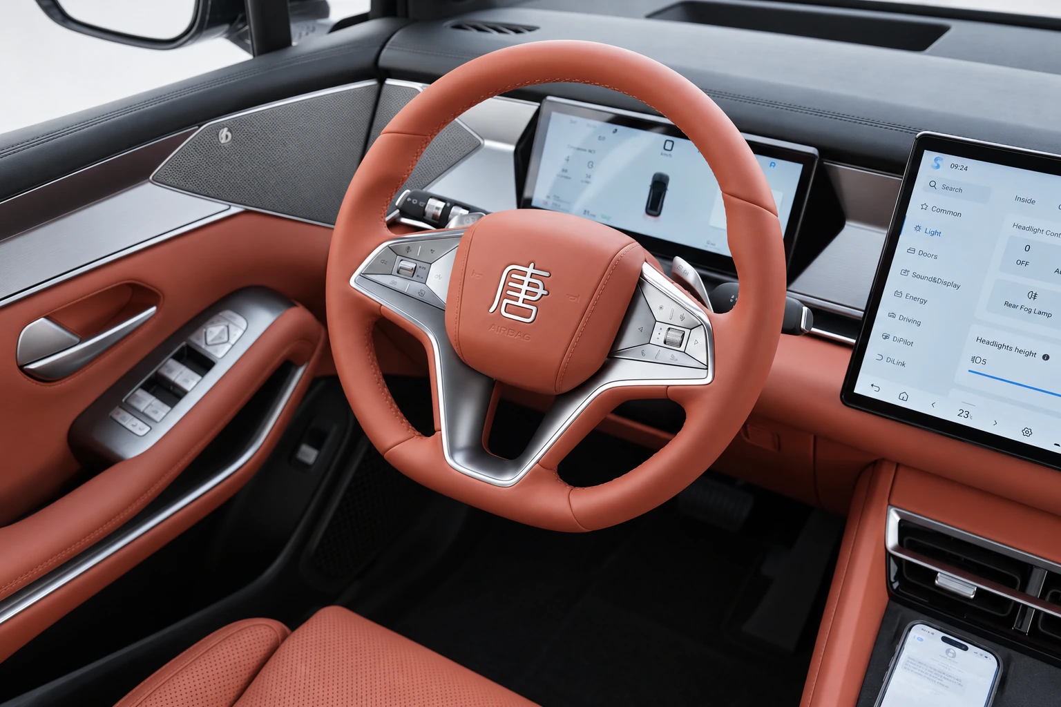 BYD Tang L, kierownica, zestaw wskaźników i panel drzwi oglądane od strony kierowcy.