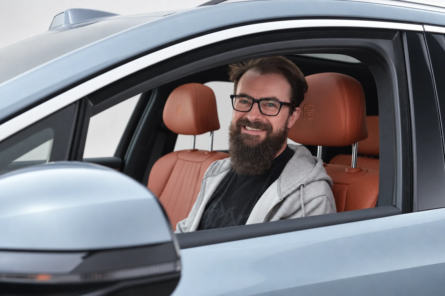 BYD Tang L, mężczyzna w okularach na fotelu kierowcy widziany przez otwarte okno.