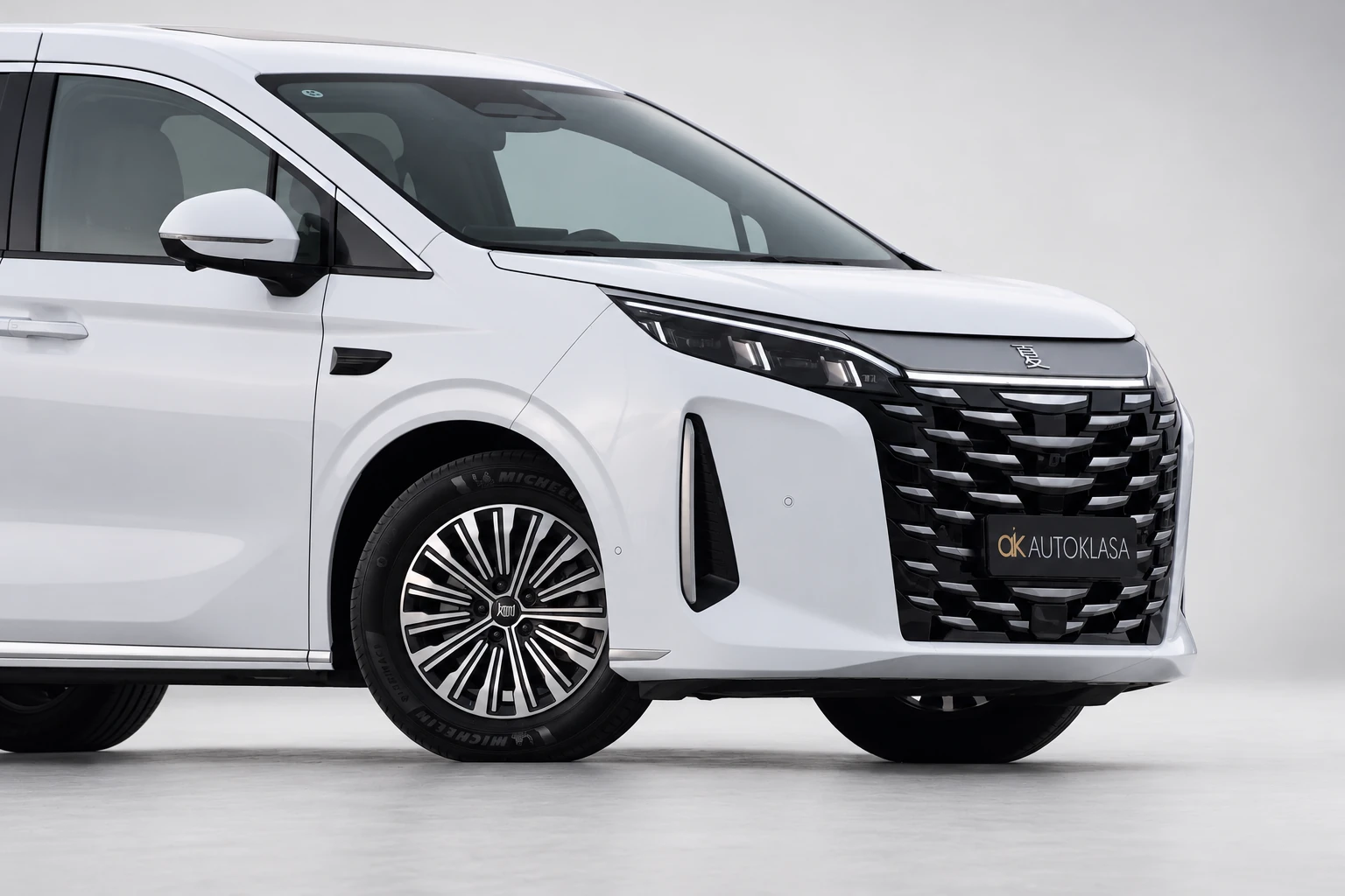 BYD Xia, przedni zderzak i koło z bliska, z widocznym pionowym wlotem przy grillu.