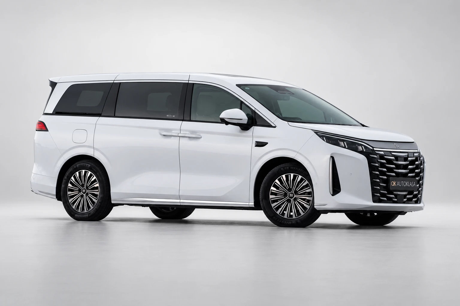 BYD Xia, szeroki widok boku i przodu pokazujący całą długość białego minivana.