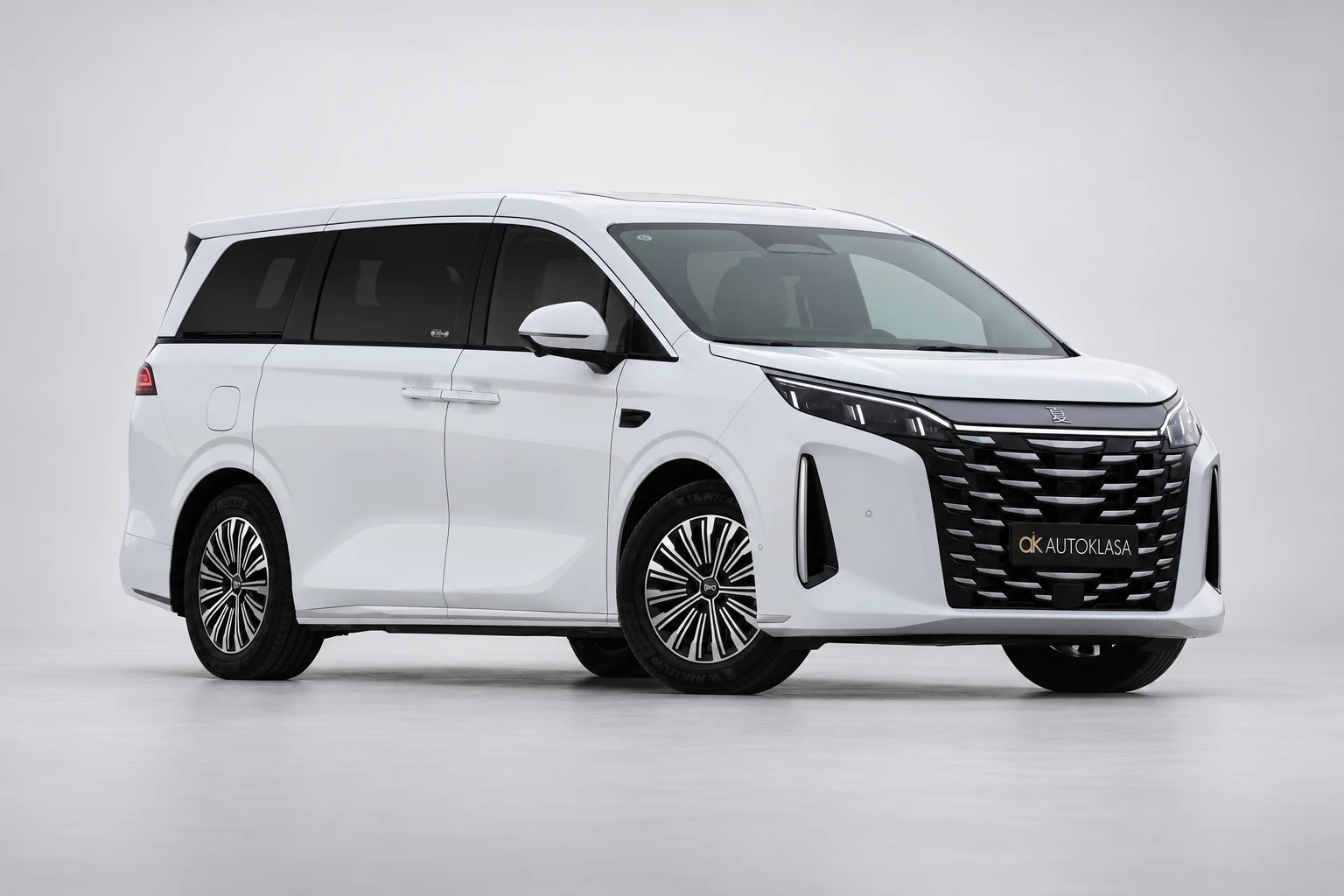 BYD Xia w białym lakierze, całe auto od przodu pod kątem na jasnym tle studyjnym.