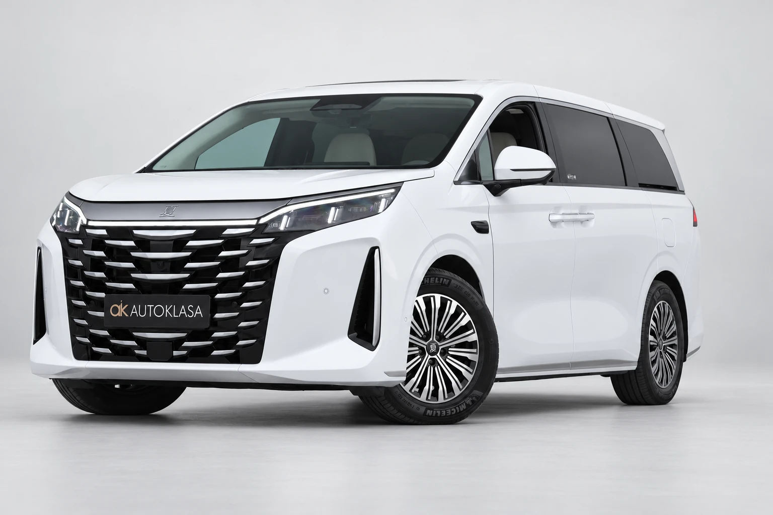BYD Xia od przodu i drugiego boku w jasnym studiu, z całą białą sylwetką i wieloramiennymi kołami; ujęcie 2.