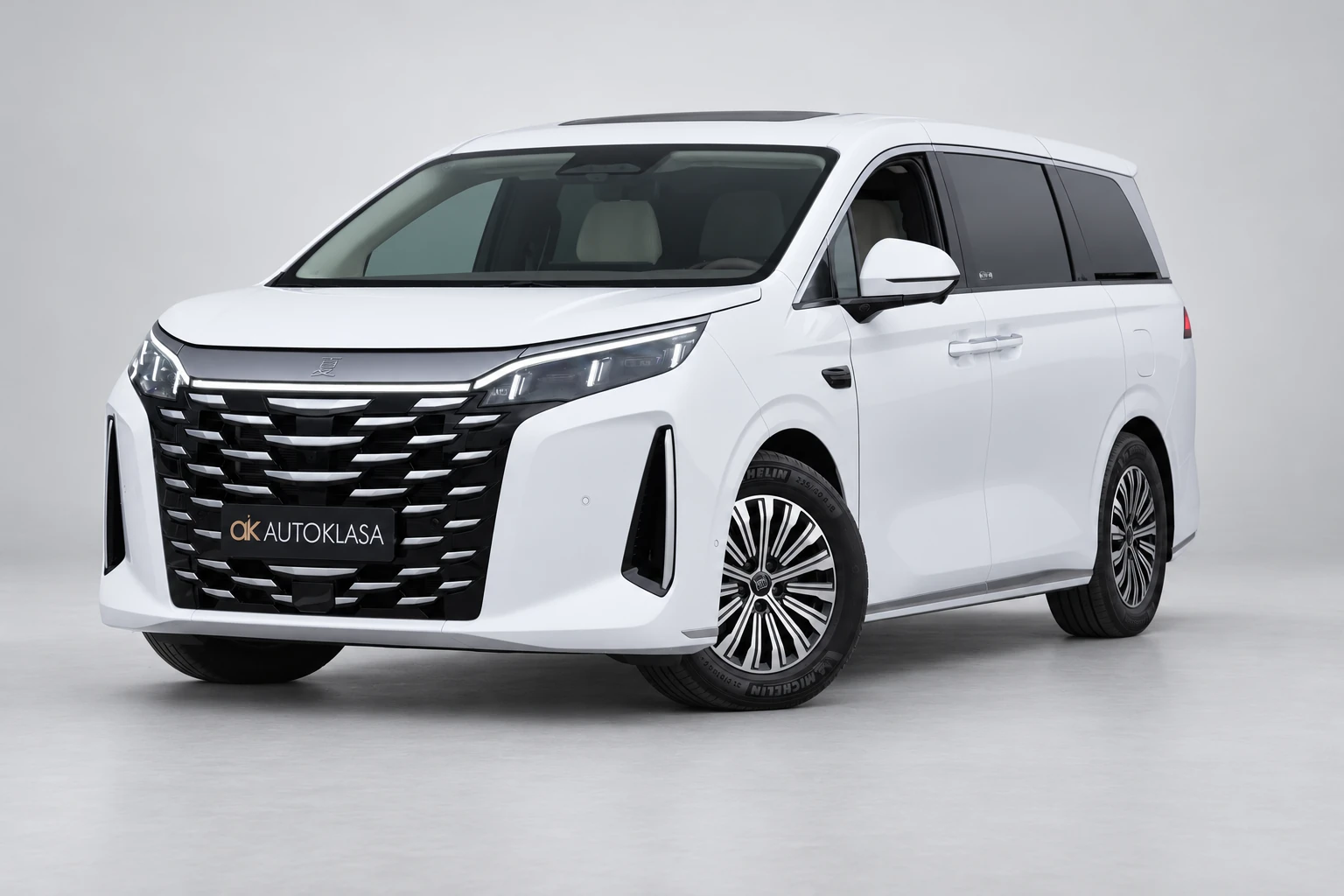 BYD Xia od przodu i drugiego boku w jasnym studiu, z całą białą sylwetką i wieloramiennymi kołami; ujęcie 3.