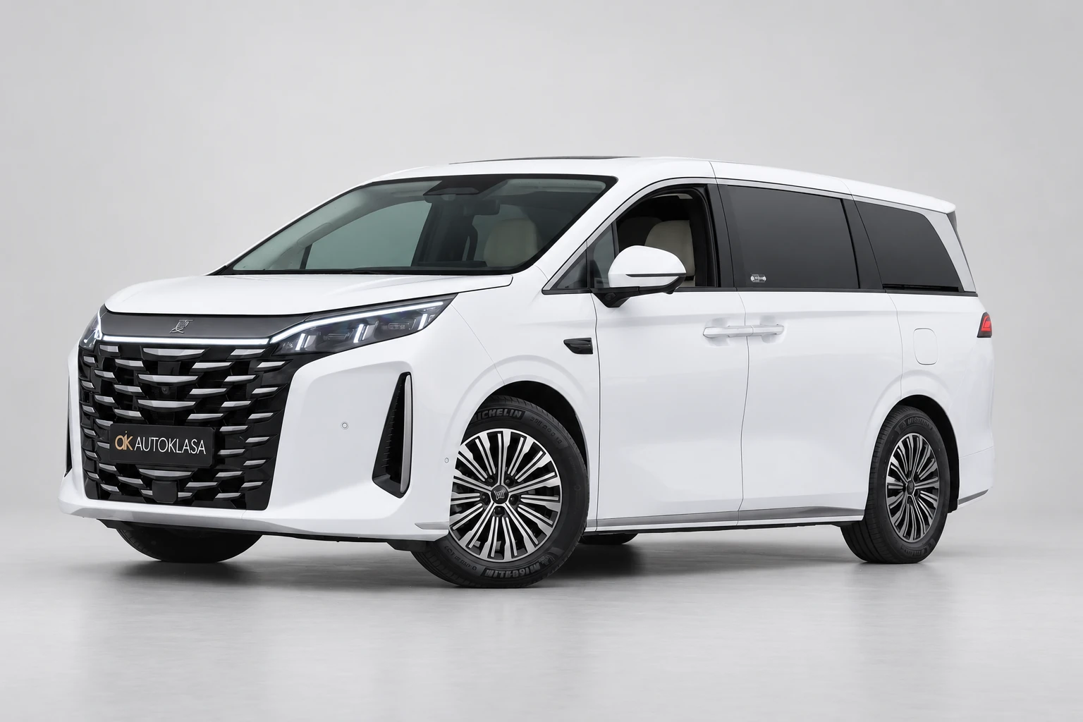 BYD Xia od przodu i drugiego boku w jasnym studiu, z całą białą sylwetką i wieloramiennymi kołami; ujęcie 5.