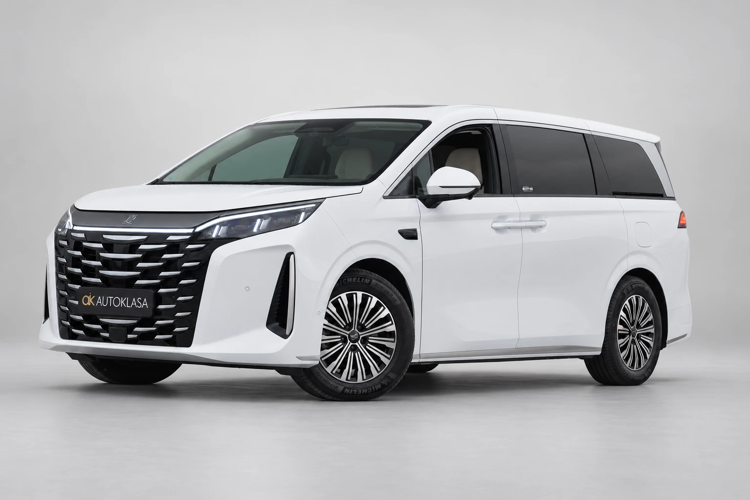 BYD Xia od przodu i drugiego boku w jasnym studiu, z całą białą sylwetką i wieloramiennymi kołami; ujęcie 6.