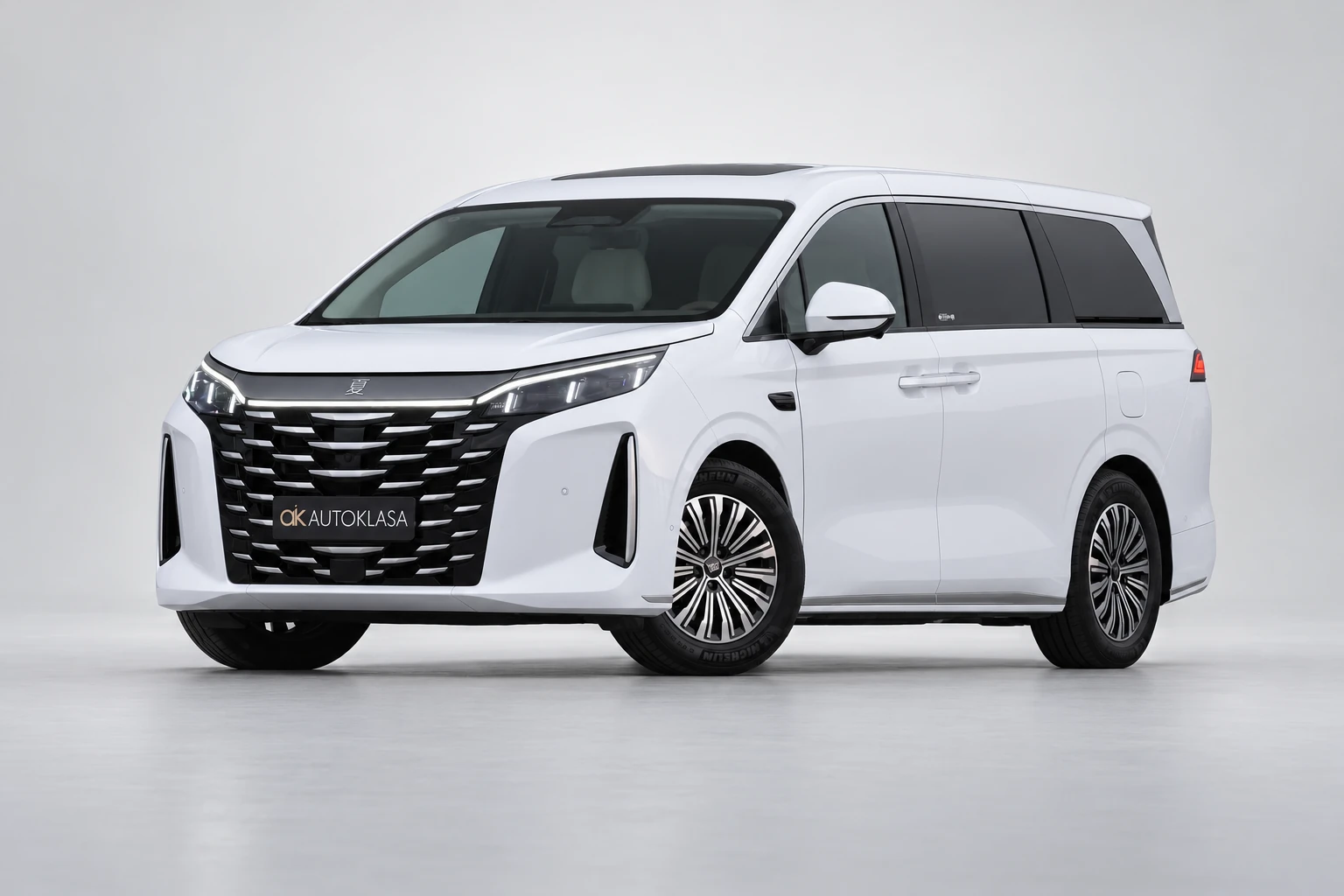 BYD Xia od przodu i drugiego boku w jasnym studiu, z całą białą sylwetką i wieloramiennymi kołami; ujęcie 7.