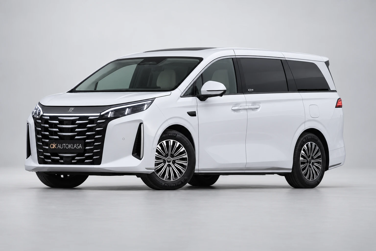 BYD Xia od przodu i drugiego boku w jasnym studiu, z całą białą sylwetką i wieloramiennymi kołami; ujęcie 9.