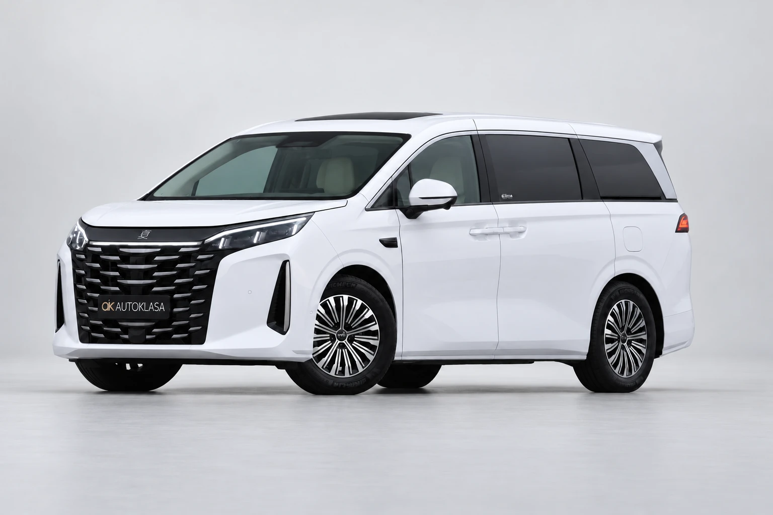 BYD Xia od przodu i drugiego boku w jasnym studiu, z całą białą sylwetką i wieloramiennymi kołami; ujęcie 10.