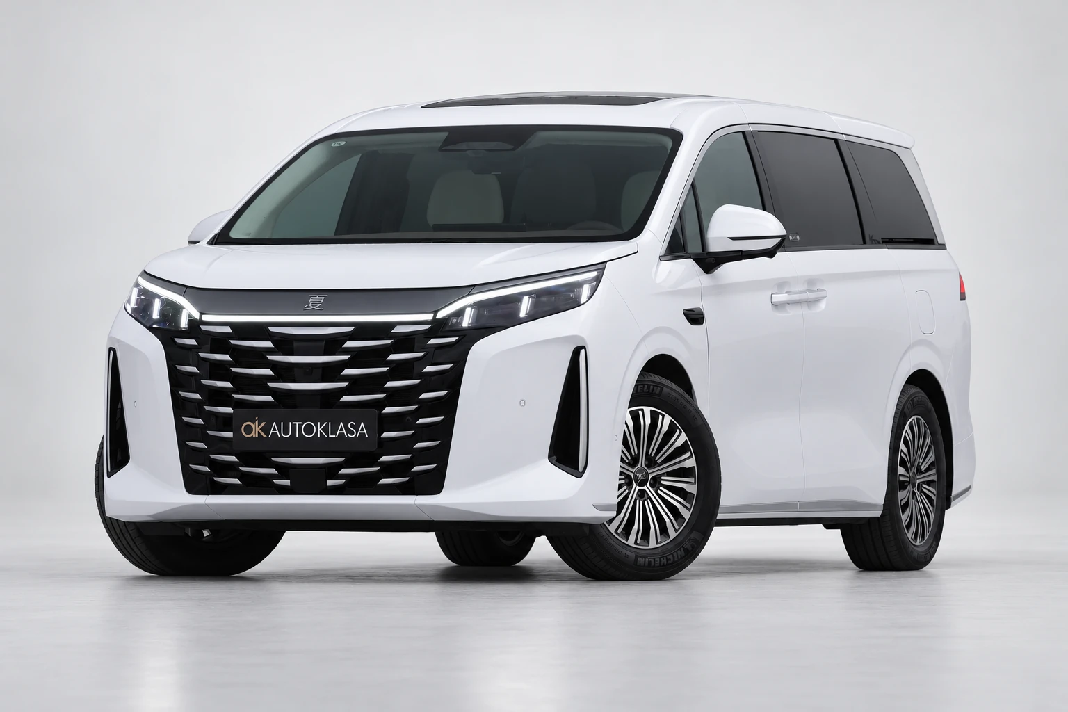 BYD Xia od przodu i drugiego boku w jasnym studiu, z całą białą sylwetką i wieloramiennymi kołami; ujęcie 12.