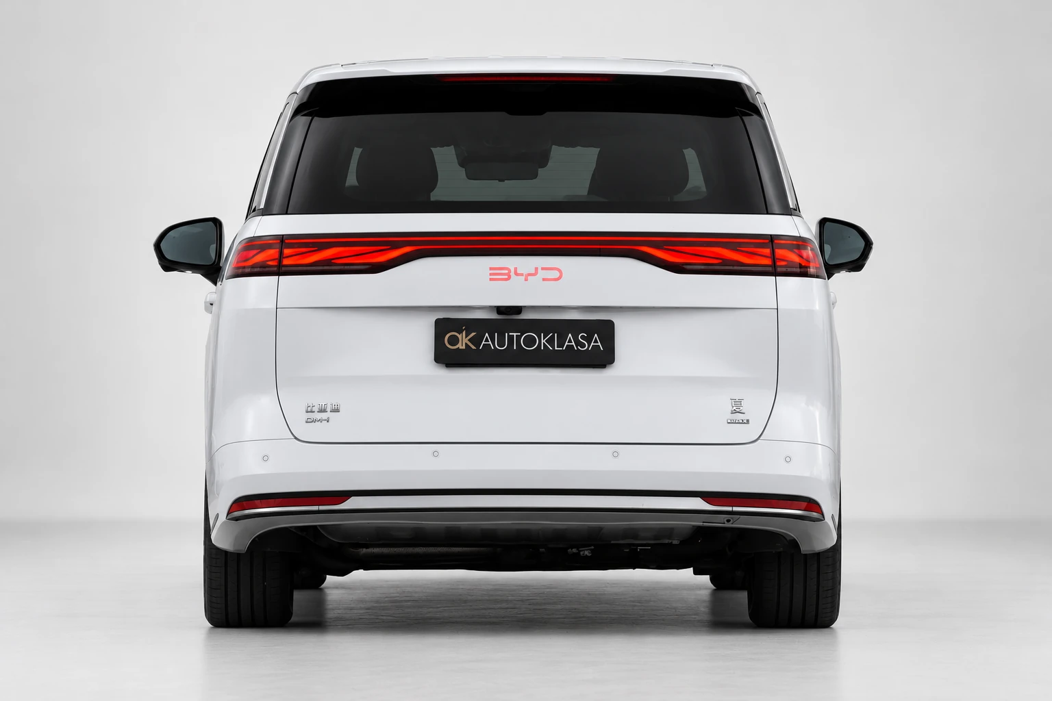 BYD Xia na wprost od tyłu, z czerwoną listwą lamp i tablicą Autoklasa; ujęcie pierwsze.
