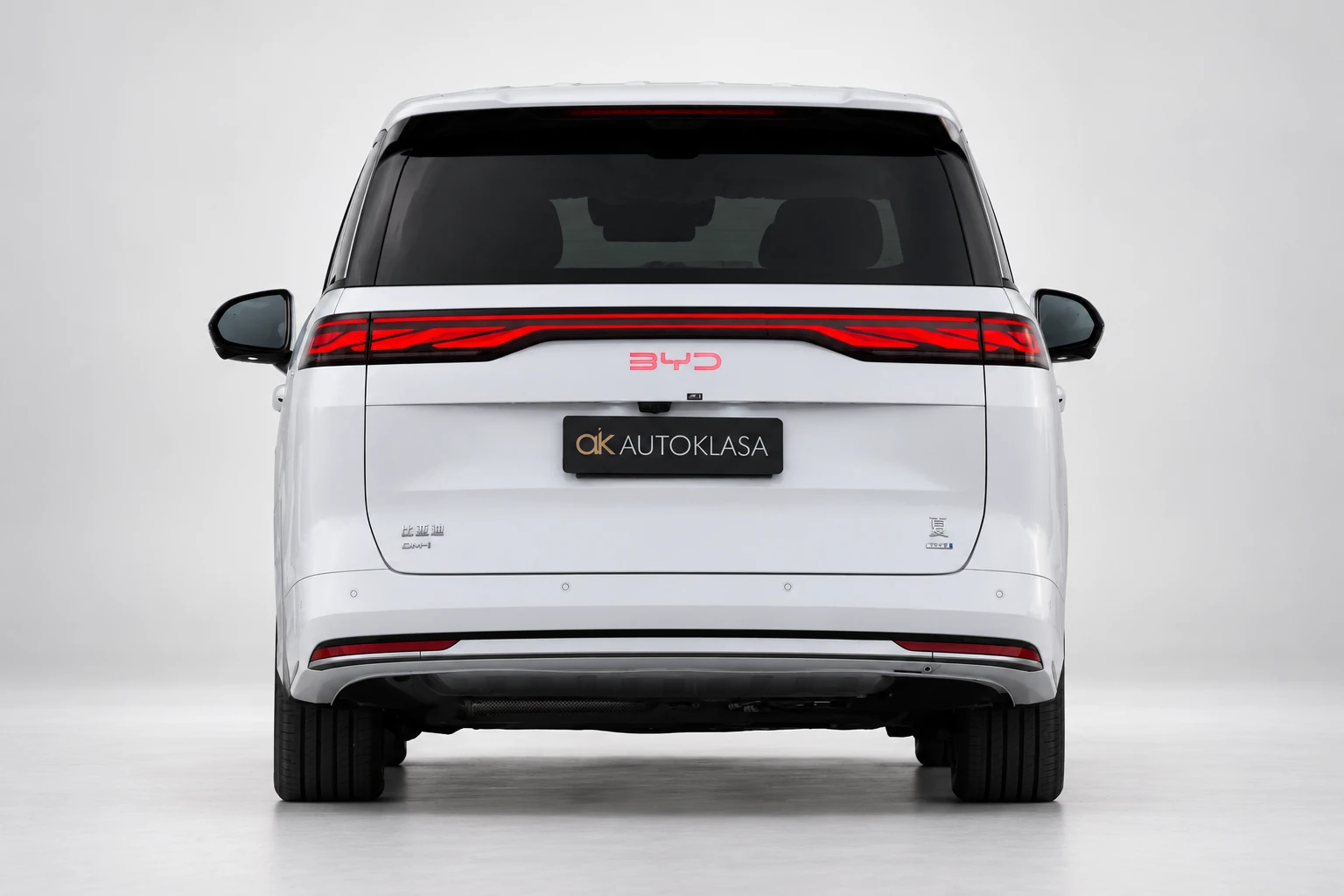 BYD Xia na wprost od tyłu, z czerwoną listwą lamp i tablicą Autoklasa; ujęcie drugie.