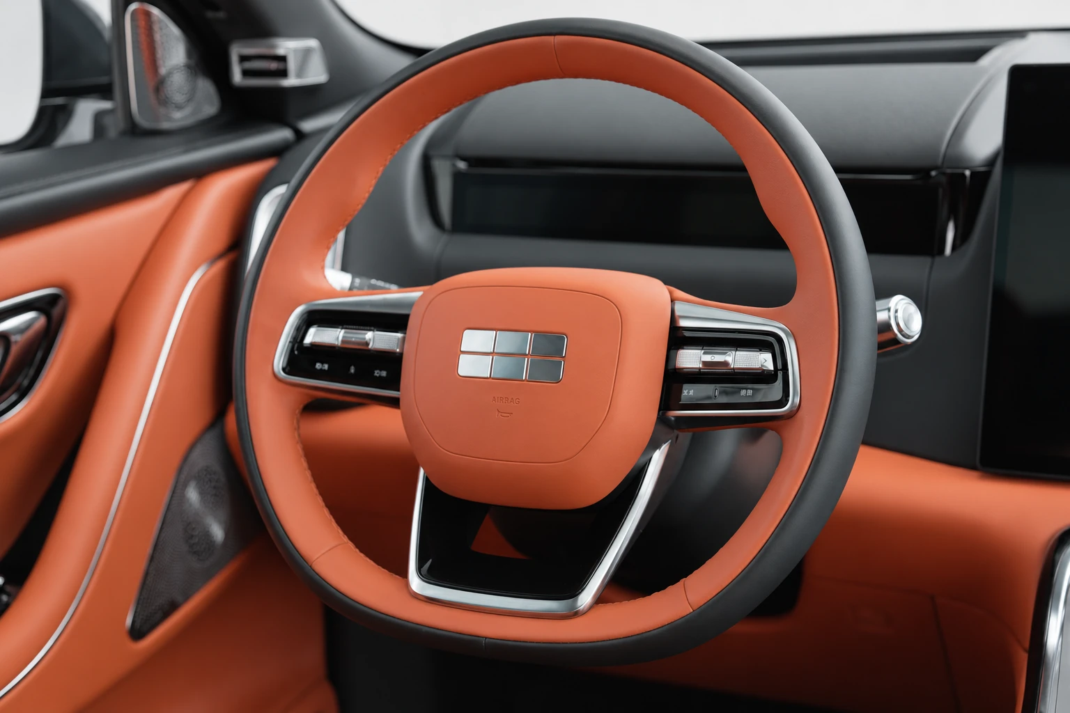 Kierownica Geely Galaxy M9 na wprost, z segmentowym emblematem i przyciskami.