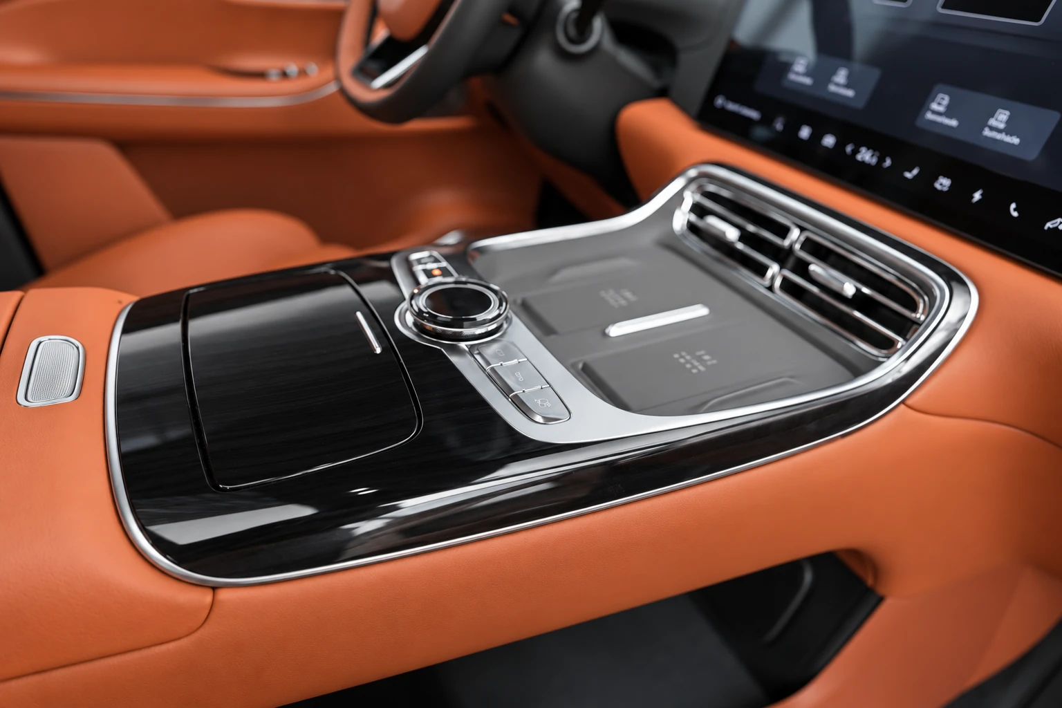 Konsola środkowa Geely Galaxy M9 pod kątem, z pokrętłem, panelem i ciemnym wykończeniem.