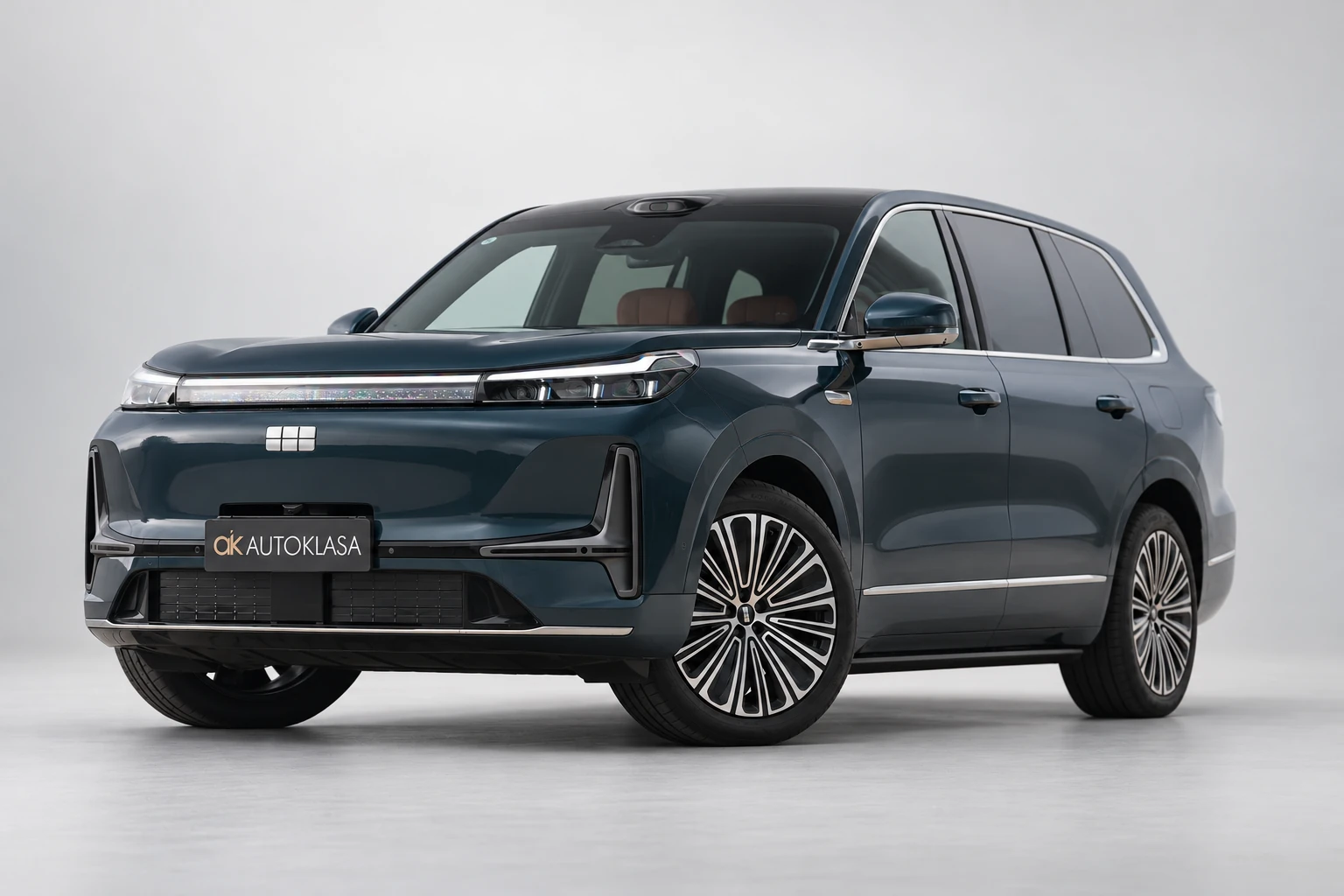 Przód Geely Galaxy M9 w bliższym kadrze trzy czwarte, z lampami i wieloszprychową felgą.