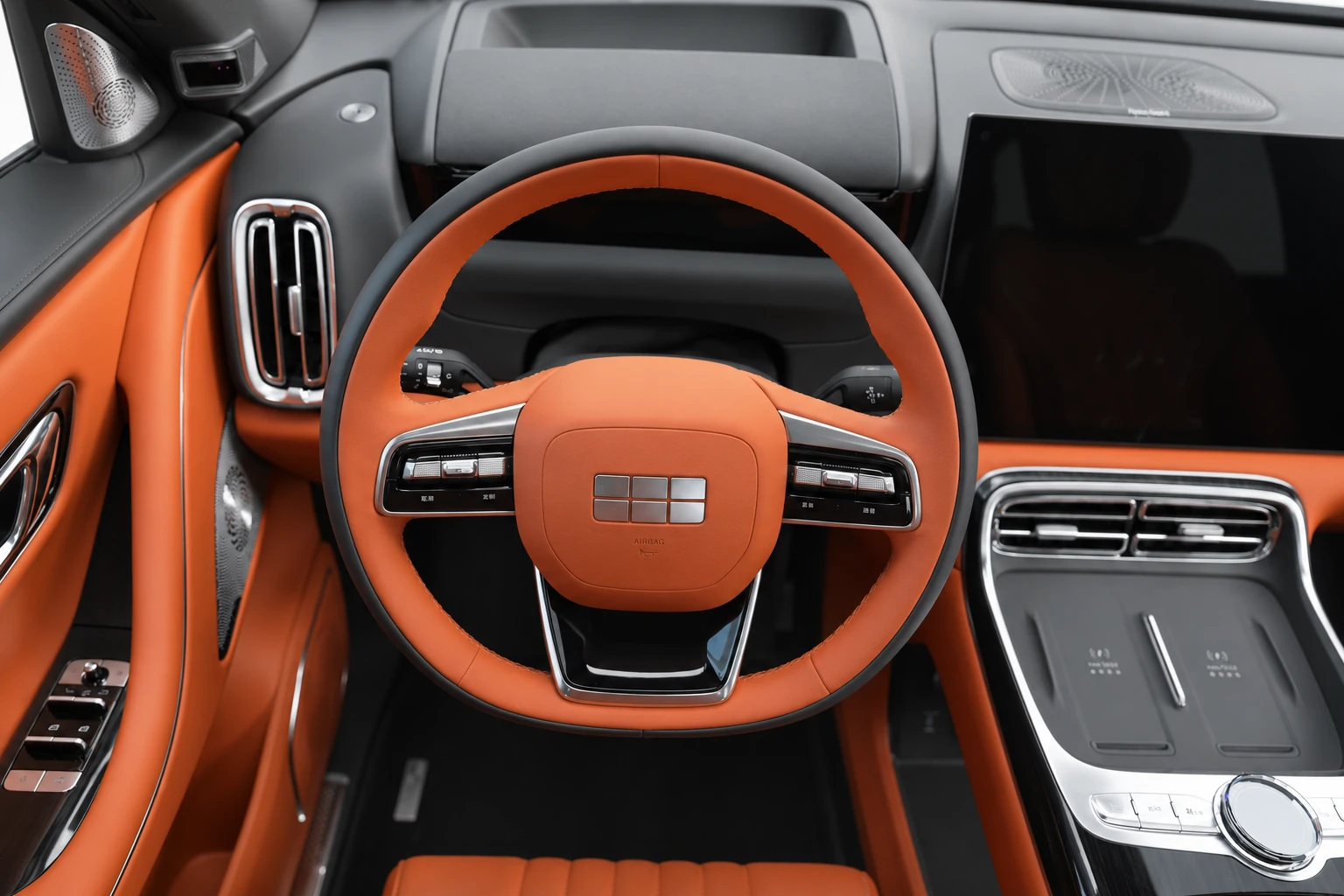 Kokpit Geely Galaxy M9 widziany z góry, z kierownicą, ekranami i konsolą środkową.