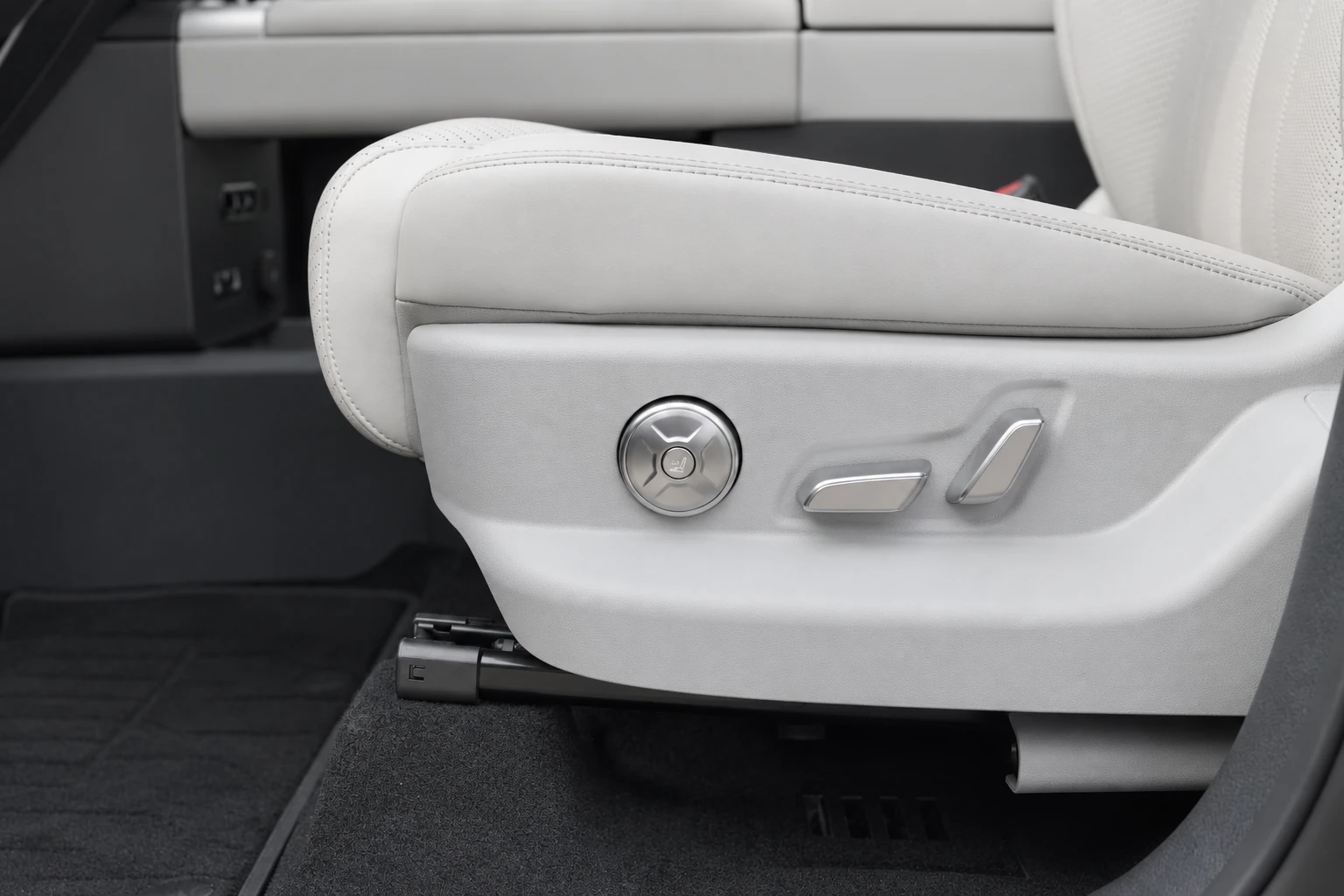 Bok jasnego siedziska BYD Leopard 7 z przyciskami regulacji nad czarną podłogą.