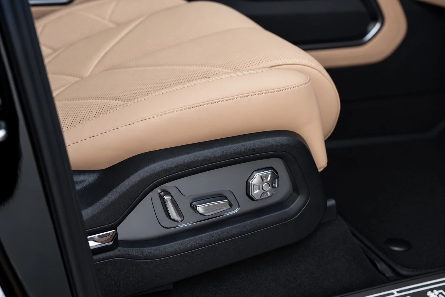 Boczne przyciski beżowego fotela BYD Leopard 8 w czarnym panelu pod siedziskiem.