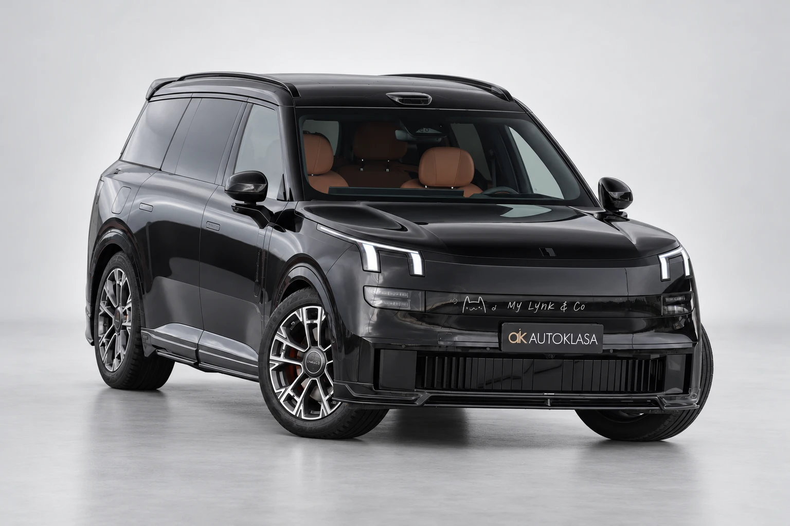 Lynk & Co 900 z widocznym przodem i pomarańczowymi fotelami za przednią szybą.