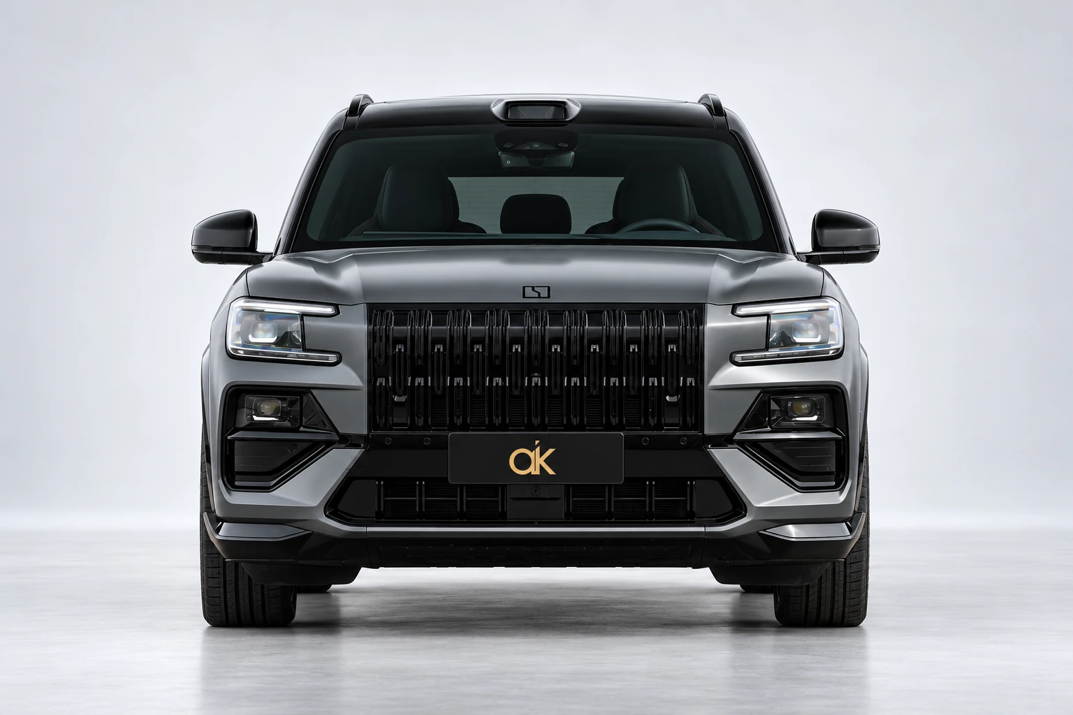 Wizualizacja studyjna szarego Zeekr 8X: cały przód, czarny grill i tablica ze złotym monogramem Autoklasy.